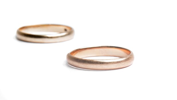 two worn golden rings on white