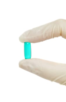 blue pill in hand with medical gloves