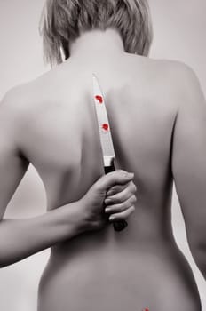 bare woman back with knife.toned picture..