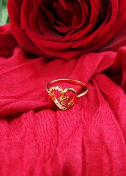 red rose and ring with red fabric background.shallow dof