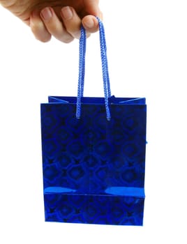 blue holiday gift bag in hand