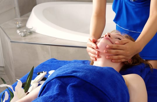 blond woman getting massage in spa salon