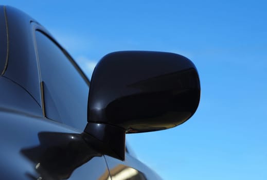 modern car mirror closeup on sky background