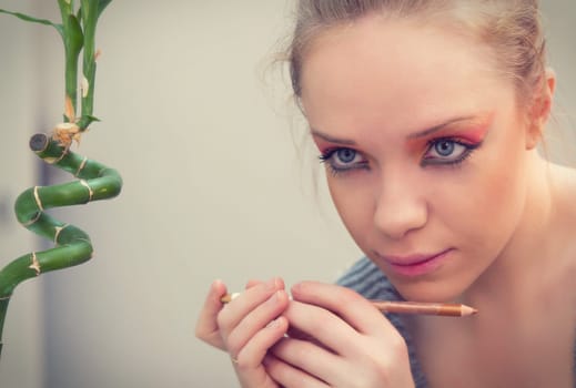 woman applying make up in front of mirror