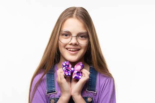 Cheerful girl in glasses holds a beautiful blue bow in her hands