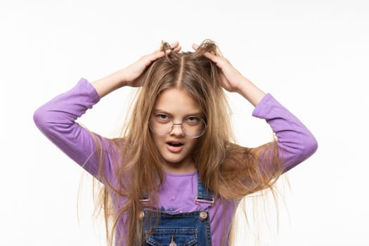 Long-haired girl scratches her head with her hands