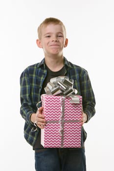 The boy laughs at the present, holding it in his hands