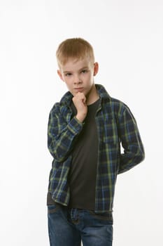 Portrait of a pensive boy in a plaid shirt on a white background