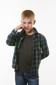 A ten year old boy wipes his nose with his finger