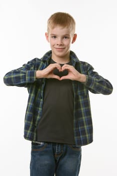 A boy of ten years shows a heart with two hands on his chest