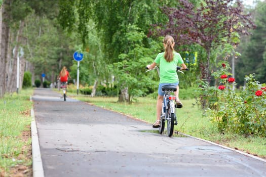 Girl rides on a special bike path in a city park