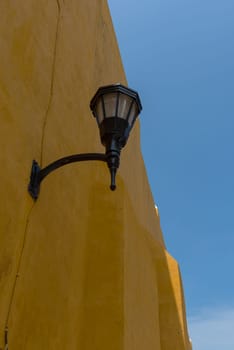 Street lamp on a yellow house wall in Campeche, Mexico