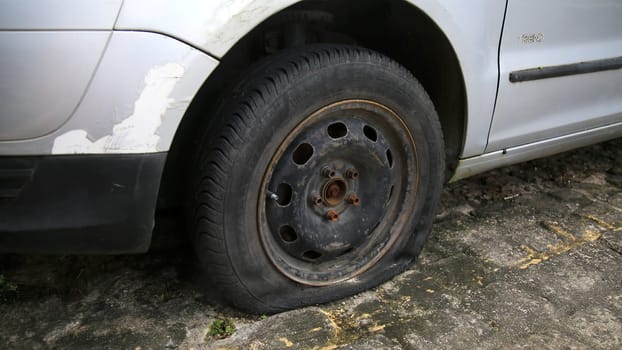 salvador, bahia / brazil - june 27, 2020: empty tire is seen in an abandoned vehicle in a condominium in the city of Salvador.