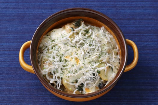 Roasted potatoes and cheese with shirasu in a dish on table