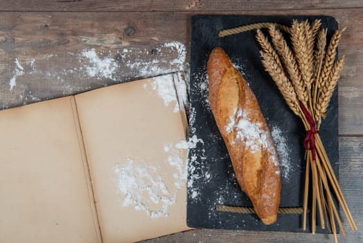 a baguette or French bread and some wheat ears, old notebook