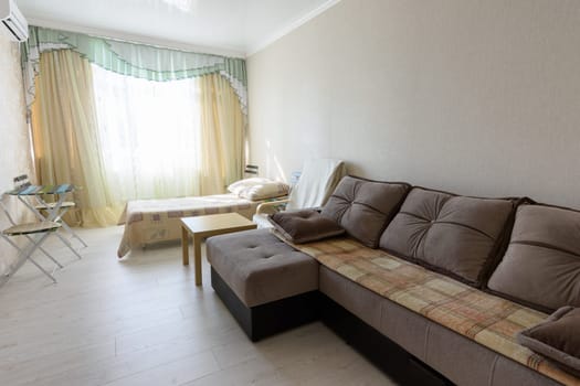 The interior of the bedroom in the apartment with a large sofa