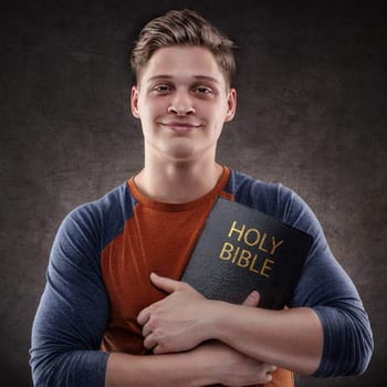 Happy young man embrace his Holy Bible