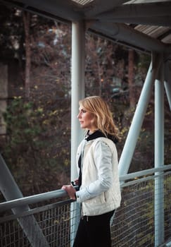 Blond woman on the bridge. Autumn time