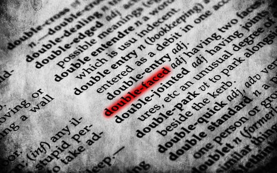 Double faced word in old textured dictionary