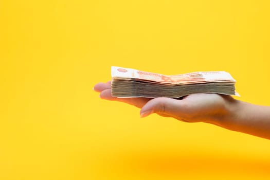 On the palm of his hand is a bundle of five thousandth bills