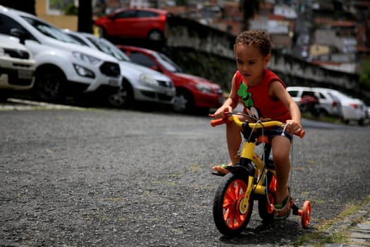 salvador, bahia / brazil - august 17, 2019: child is seen riding a bicycle in a condominium in the city of Salvador.