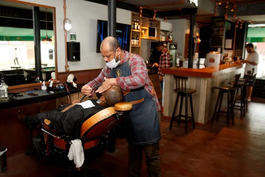 salvador, bahia / brazil - july 1. 2018: barber is seen working in a barber shop in the city of salvasdor.