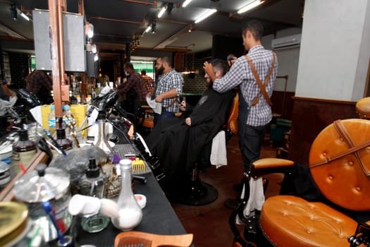 salvador, bahia / brazil - july 1. 2018: barber is seen working in a barber shop in the city of salvasdor.