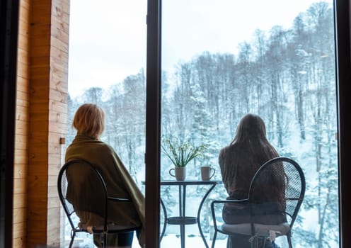Family with snowdrops and drink mugs on balcony, Winter time