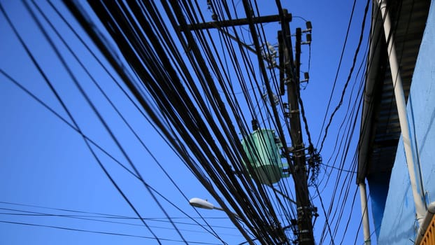 salvador, bahia / brazil - july 1, 2020: electrical network transformer is seen amidst pole wiring in the neighborhood of Pernambues, in the city of Salvador..