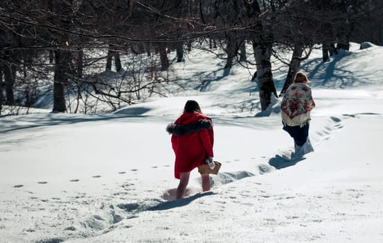 Girl with mum walking in the snow