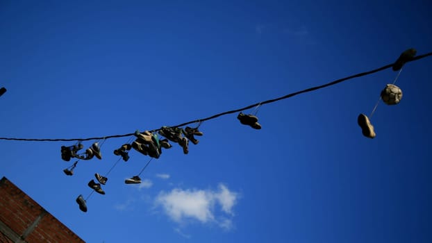 salvador, bahia / brazil - july 1, 2020: shoes are seen hanging from the electrical network's wiring in the neighborhood of Pernambues, in the city of Salvador.