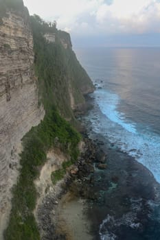 Uluwatu Temple Pura Luhur Uluwatu is a Balinese Hindu sea temple located in Uluwatu. It is renowned for its magnificent location, perched on top of a cliff. Picturesque bright cliff landscape.