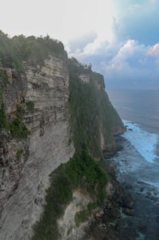 Uluwatu Temple Pura Luhur Uluwatu is a Balinese Hindu sea temple located in Uluwatu. It is renowned for its magnificent location, perched on top of a cliff. Picturesque bright cliff landscape.