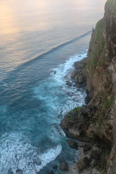Beautiful Panoramic view of an Iconic Famous Place, Uluwatu Temple, during a vibrant summer sunrise. Amazing views at Pura Luhur Uluwatu temple in Bali Island. Nice colourful sunset with clouds.