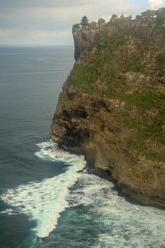 Uluwatu Temple Pura Luhur Uluwatu is a Balinese Hindu sea temple located in Uluwatu. It is renowned for its magnificent location, perched on top of a cliff. Picturesque bright cliff landscape.