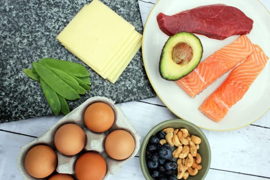 low carb ketogenic gluten free paleo style diet protein based meat fish dairy eggs veg berries and nuts background with copy space