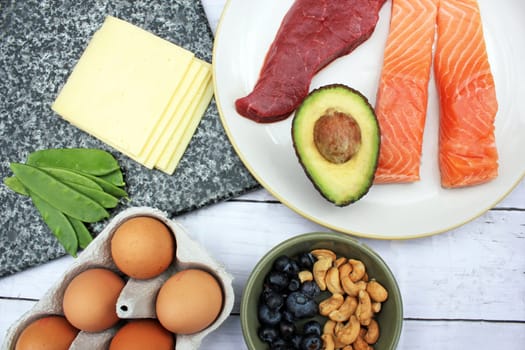 low carb ketogenic gluten free paleo style diet protein based meat fish dairy eggs veg berries and nuts background with copy space