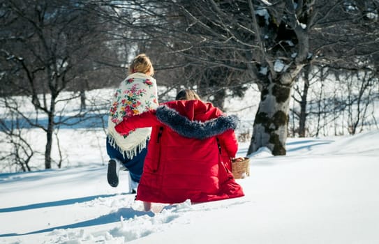 Girl with mum walking in the snow