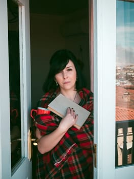 Woman on balcony with book and coffee
