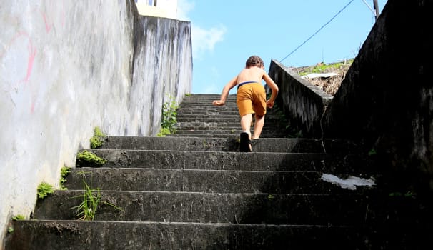 salvador, bahia / brazil - july 2, 2020: child is seen climbing stairs in residential condominium in the city of Salvador.