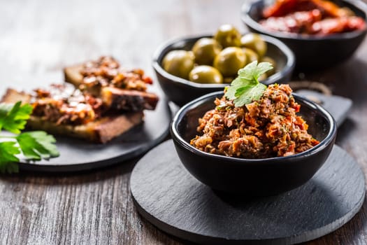 Tapenade - delicious olive paste from France with ingredients and crostini.