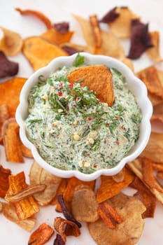 Bowl of homemade spinach dip with vegetable chips