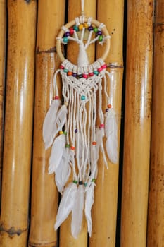 White dreamcatcher - Indian amulet that protects the sleeper from evil spirits and diseases.. The tree - symbol of life. Dream catcher on bamboo background.