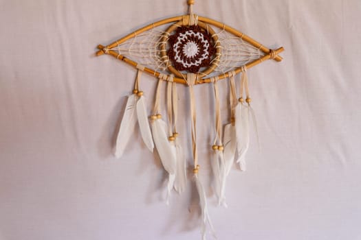 god eye of providence dreamcatcher with white feathers on a white background.