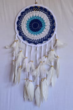 Blue Dreamcatcher with feathers and beads isolated on a white background.