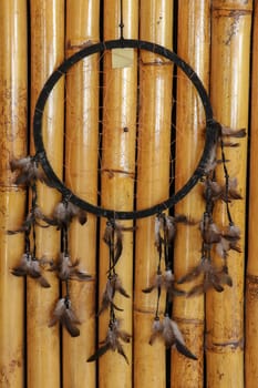 Black dream catcher on bamboo background. Indian amulet.