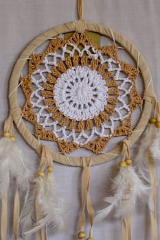 White crocheted dreamcatcher, an Indian amulet that protects the sleeper from evil spirits and diseases. Soft focus. Closeup.