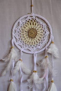 White crocheted dreamcatcher, an Indian amulet that protects the sleeper from evil spirits and diseases. Soft focus. Closeup.