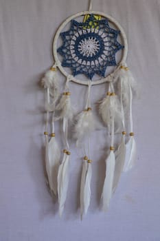 Blue Dreamcatcher with feathers and beads isolated on a white background.