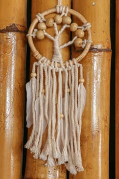 White dreamcatcher - Indian amulet that protects the sleeper from evil spirits and diseases.. The tree - symbol of life. Dream catcher on bamboo background.